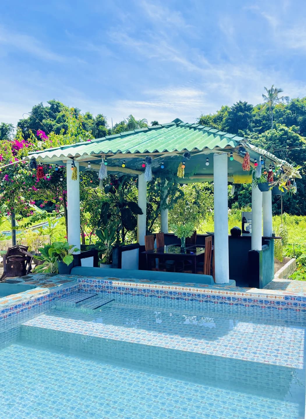 Covered ground floor veranda lounge with pool and tropical palm views