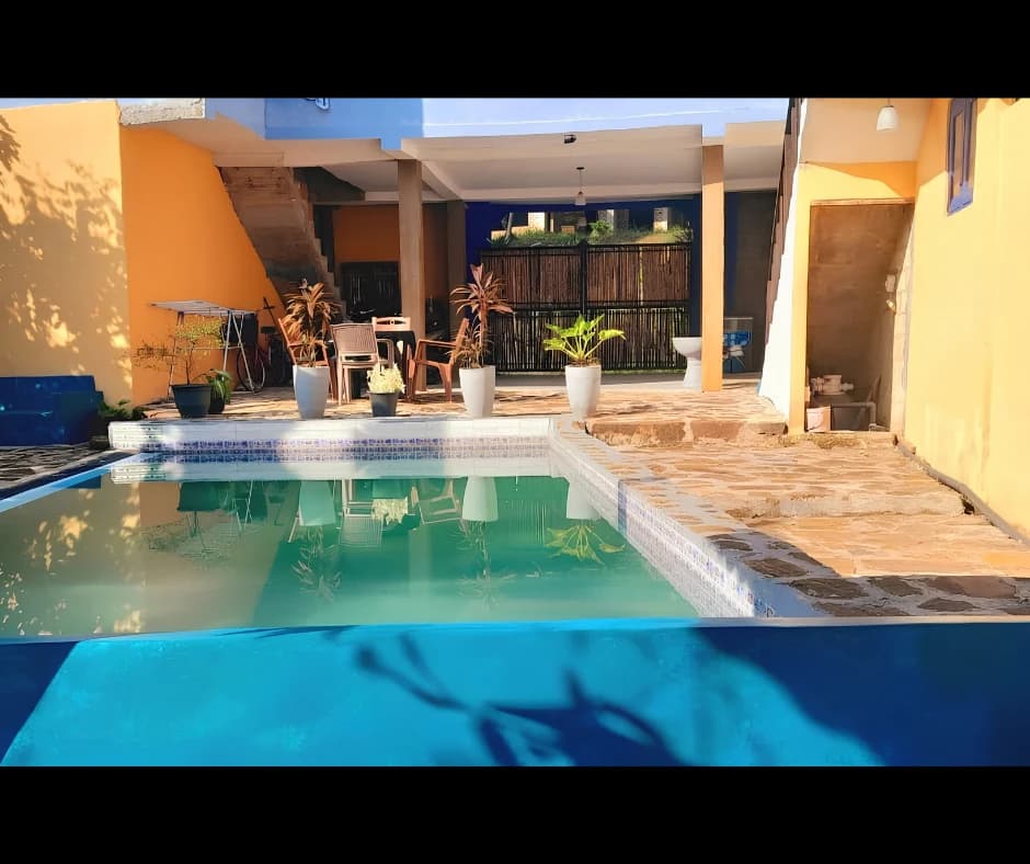 Courtyard swimming pool with reflection of yellow villa façade